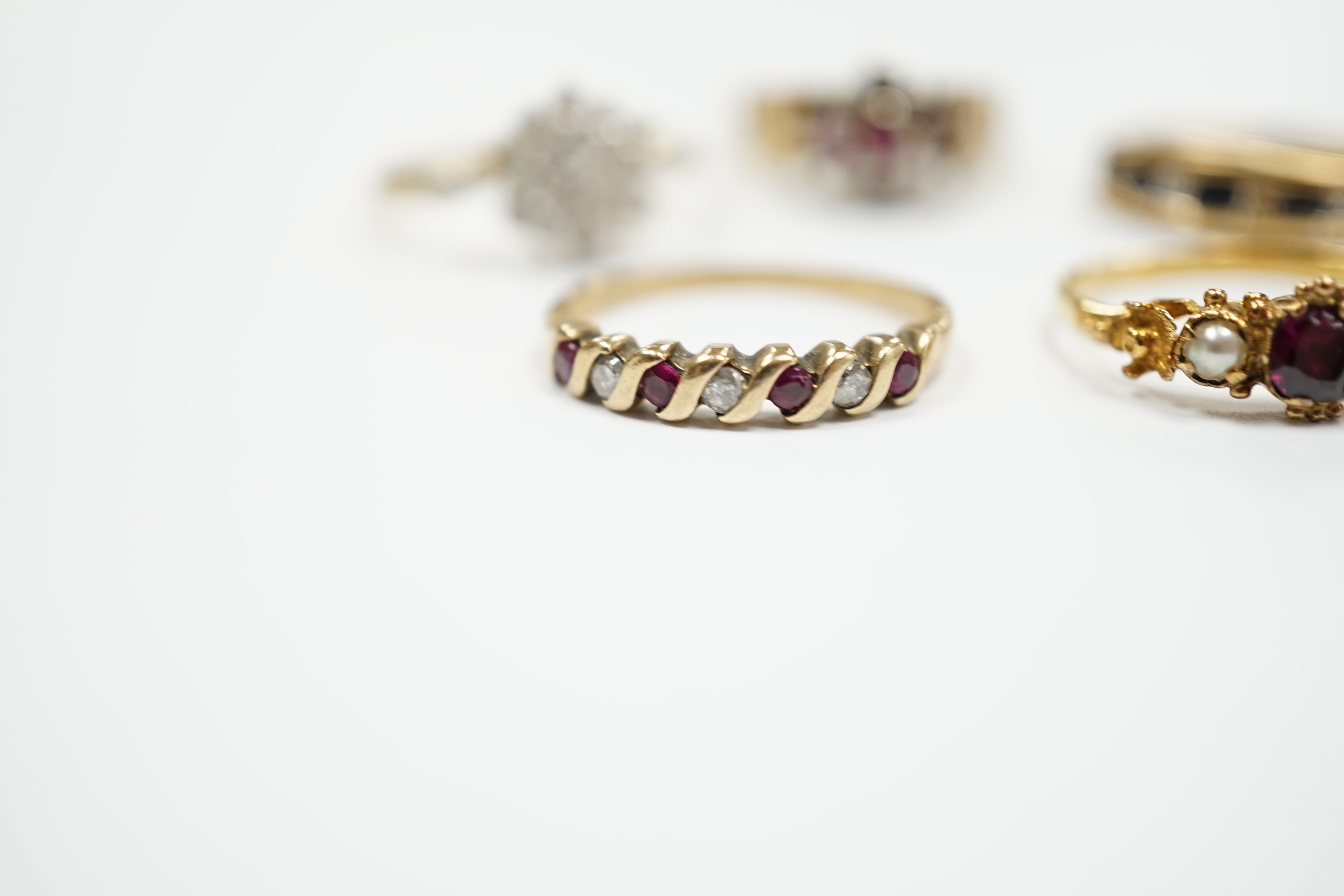 Three assorted 9ct gold and gem set rings, including ruby and diamond cluster, gross weight 7.7 grams, a 585 yellow metal and cubic zirconia set cluster ring and a yellow metal, garnet and seed pearl set ring, gross weig